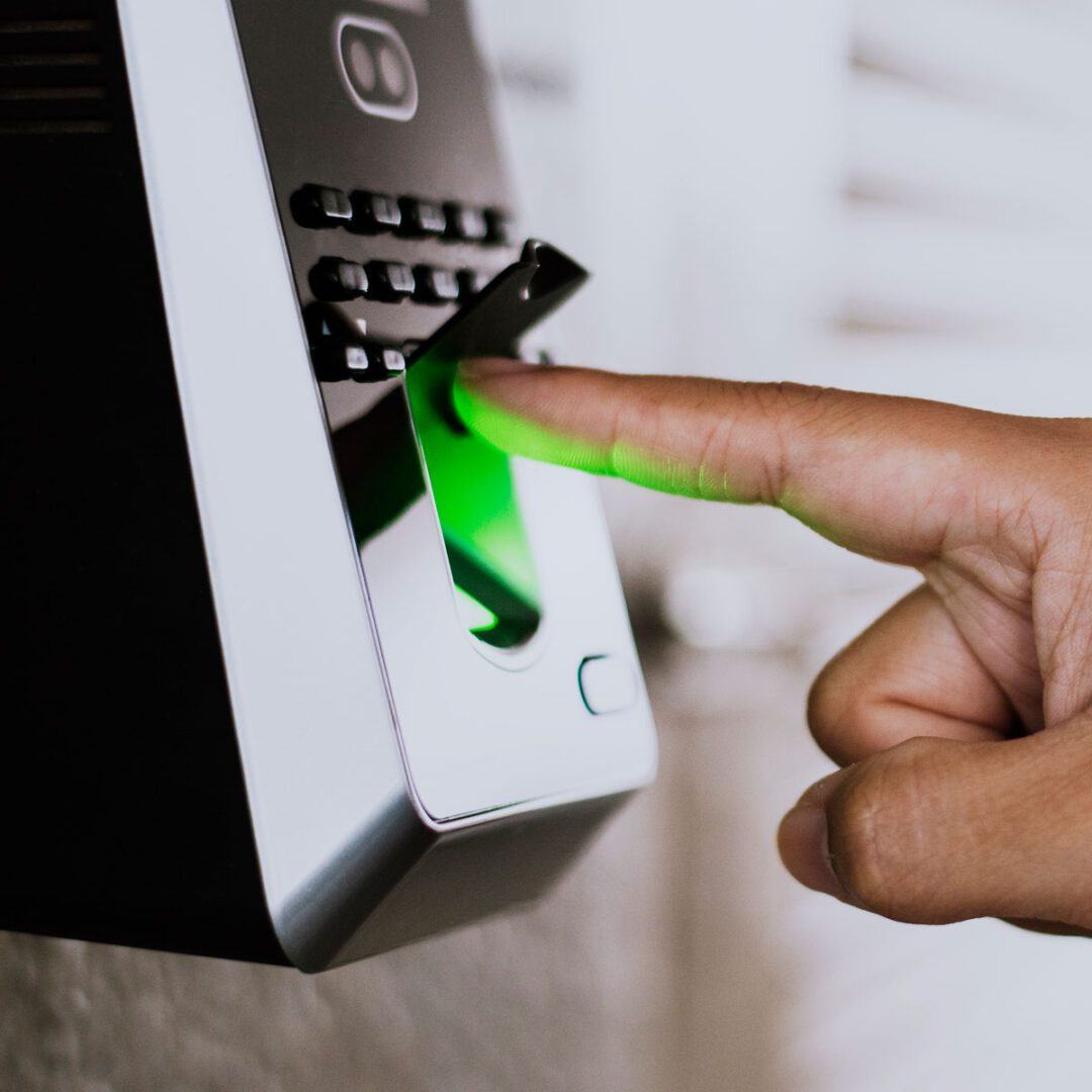 A person's finger undergoing biometric authentication on a fingerprint scanner.