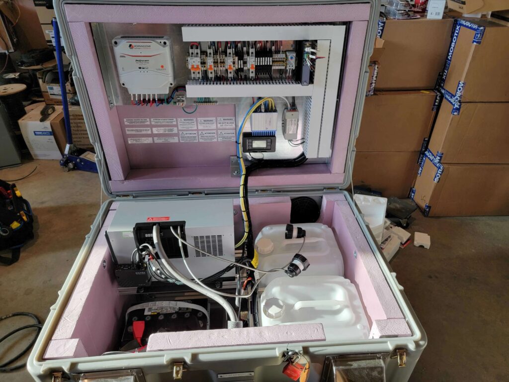 Portable industrial equipment setup within a rugged case, showing electrical components and connections.