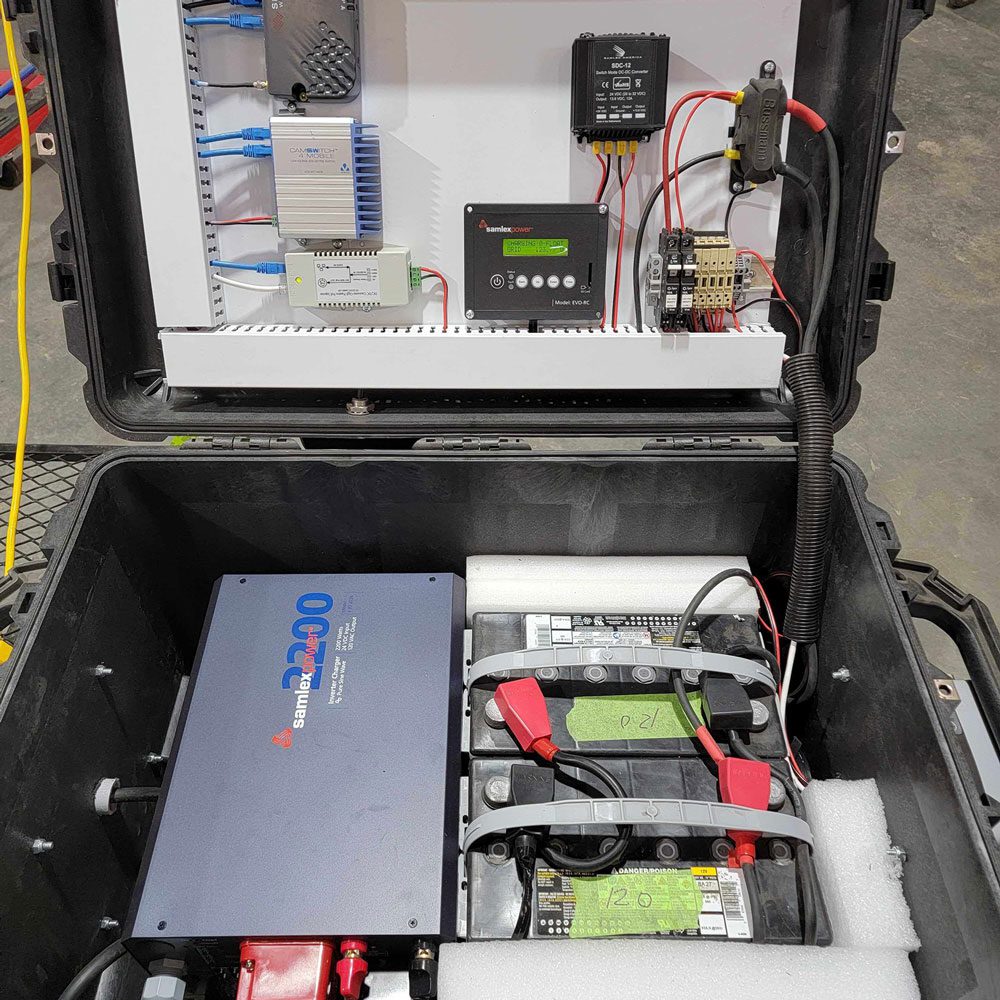 Portable electrical equipment setup inside a protective case, including a battery, inverter, and wiring.