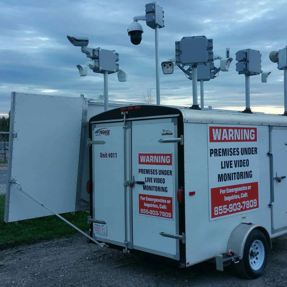 Mobile surveillance unit with multiple cameras and warning signs.