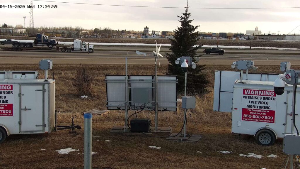 A traffic monitoring setup with warning signs, overlooking a highway with vehicles passing by.